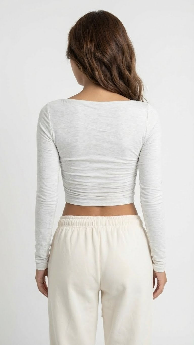 Woman wearing a gray long-sleeve top and white pants Heather White