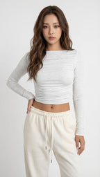 Woman wearing a gray long-sleeve top and white pants Heather White