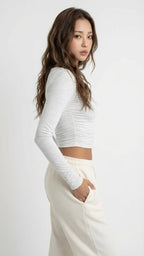 Woman wearing a gray long-sleeve top and white pants Heather White